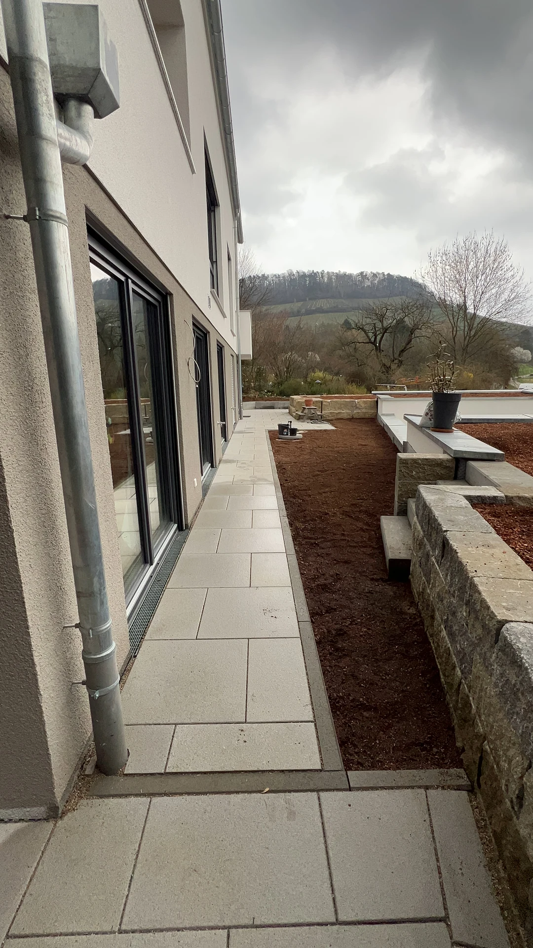 Terrassenplatten entlang der Fassade mit Randeinfassung