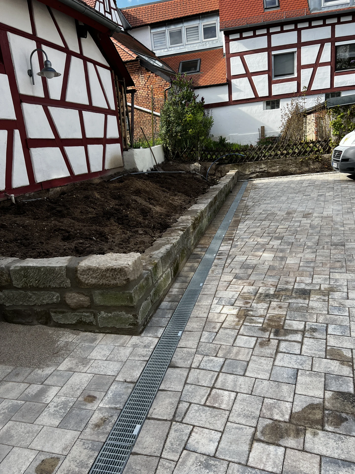 Entwässerungsrinne entlang der Natursteinmauer