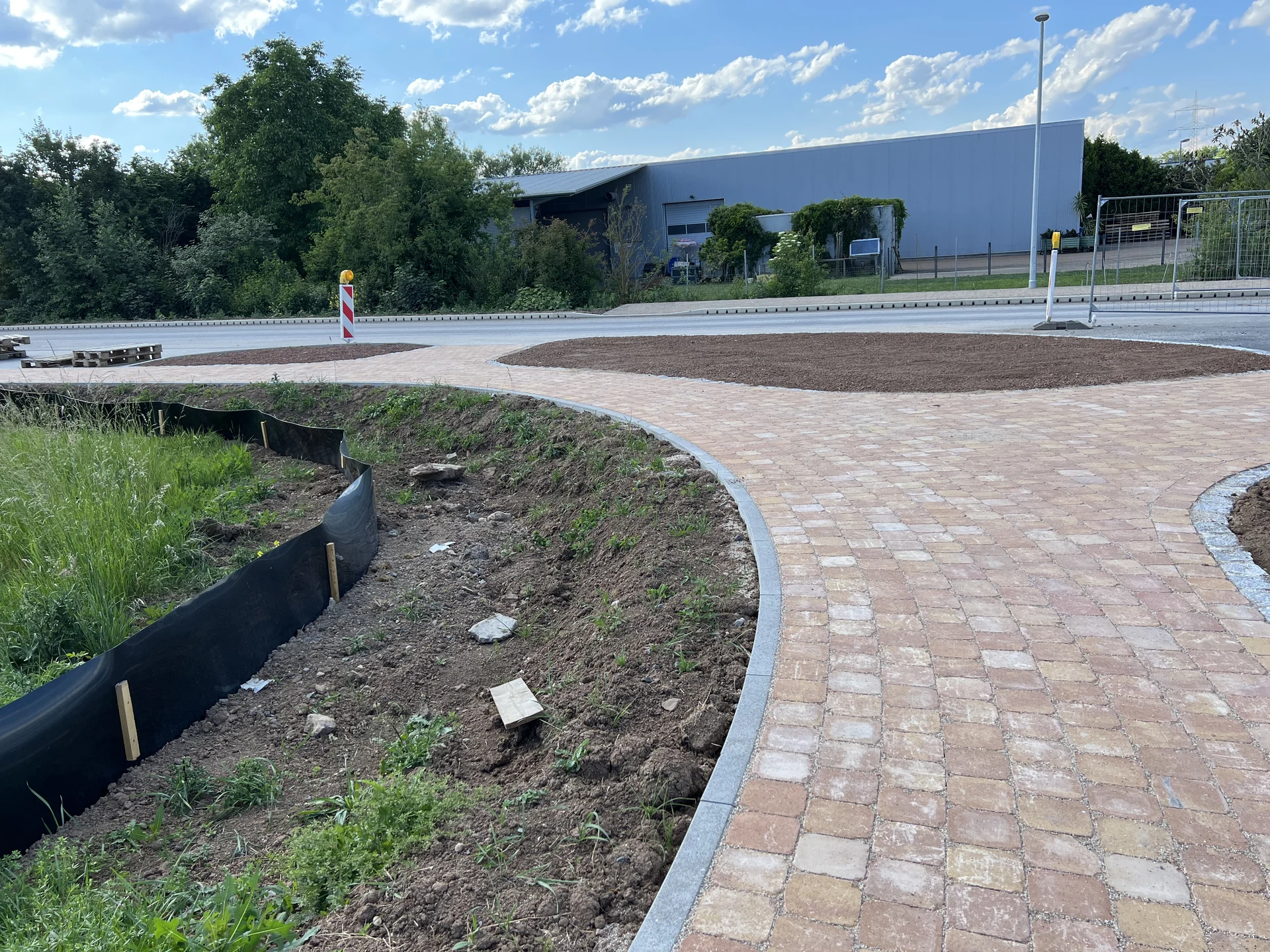 Weg zwischen Böschung und Stellflächen